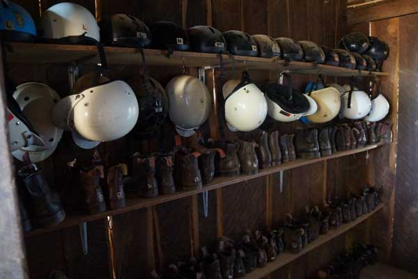 helmets and riding boots on shelves