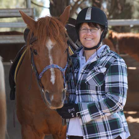 lady standing next to a horse smiling